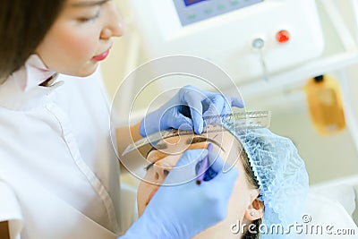 Cosmetologist shaping eyebrows before microblading. Stock Photo