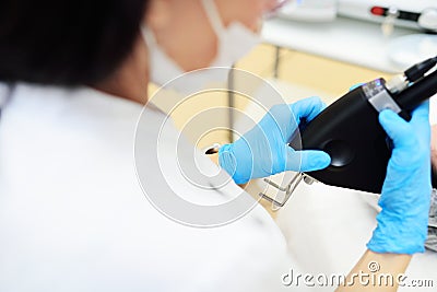 cosmetologist uses a CO2 fractional ablative laser to rejuvenate the skin and remove scars in a modern cosmetic beauty Stock Photo