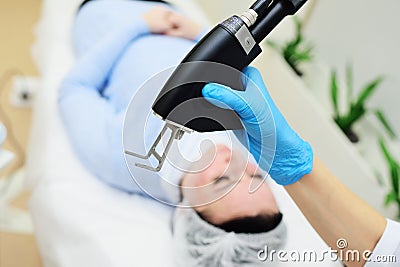 cosmetologist uses a CO2 fractional ablative laser to rejuvenate the skin and remove scars in a modern cosmetic beauty Stock Photo