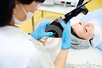 cosmetologist uses a CO2 fractional ablative laser to rejuvenate the skin and remove scars in a modern cosmetic beauty Stock Photo