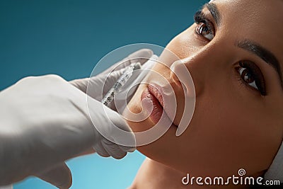 Cosmetologist using syringe to correct female face. Stock Photo