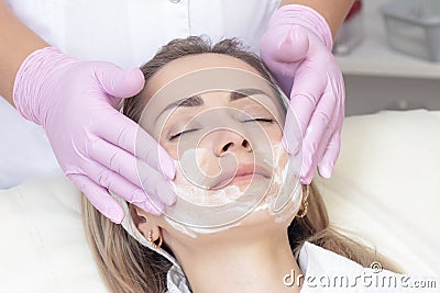 Cosmetology. Close up picture of lovely young woman with closed eyes receiving facial cleansing procedure Stock Photo