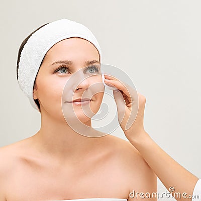 Cosmetology doctor remove mascara from girl face. Cotton pad with woman hands. Demakeup lotion Stock Photo