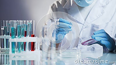 Cosmetology lab assistant preparing organic substance for anti-aging cream Stock Photo