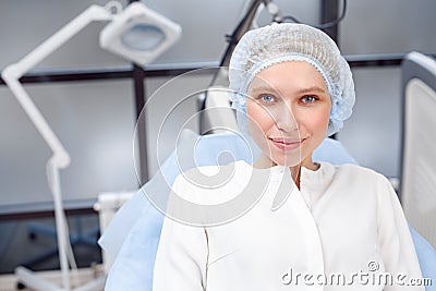 Cosmetology Service. Young patient in hair cap at beauty clinic close-up smiling confident Stock Photo