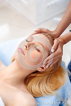 Cosmetology Service. Young woman at beauty clinic lying relaxed while doctor touching head preparation for procedure Stock Photo