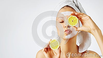 Cosmetology, skin care, face treatment, spa and natural beauty concept. Woman with facial mask holds lemons Stock Photo