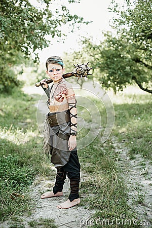 cosplay of Ukrainian Kozak. Cute Caucasian boy holding mace with emblem of Ukraine pretending to be fearless warrior Stock Photo