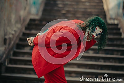 Cosplayer in the image of a crazy clown stands handcuffed Stock Photo