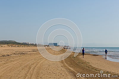 People taking morning walk exercise on beautiful natural beach between Torre La mata and Guardamar de Segura Costa Blanca Spain Editorial Stock Photo