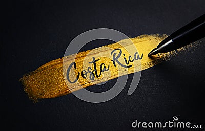 Costa Rica Handwriting Text on Golden Paint Brush Stroke Stock Photo