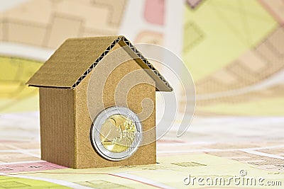 Costs about buildinh activity - Housing concept with cardboard house, euro coins and imaginary cadastral map Stock Photo