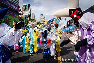 Costumed people dance and play in the street during the pre-carn Editorial Stock Photo