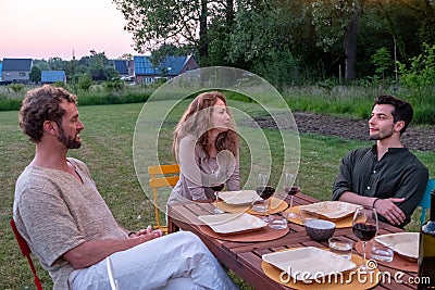 Cosy Evening Chat Among European Friends in Garden at Sunset Stock Photo