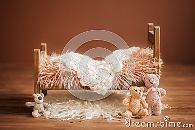 Cot for a newborn on a brown background with toys and a white rug, background Stock Photo