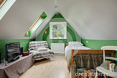 Cottage attic style bedroom with steeply sloping ceiling Editorial Stock Photo