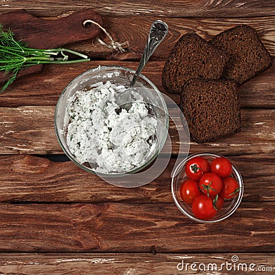 Cottage cheese in bowl of glass, cherry tomatoes, dill and bread Stock Photo