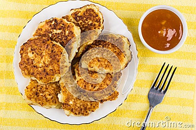 Cottage cheese pancakes, apricot jam, fork on yellow napkin Stock Photo