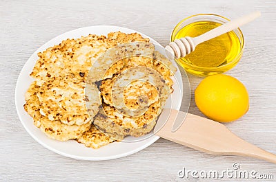 Cottage cheese pancakes in plate, honey and lemon on table Stock Photo