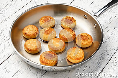 Cottage cheese pancakes. Syrniki in a frying pan. Stock Photo