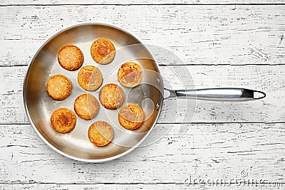 Cottage cheese pancakes. Syrniki in a frying pan. Cheesecakes, top view. Stock Photo