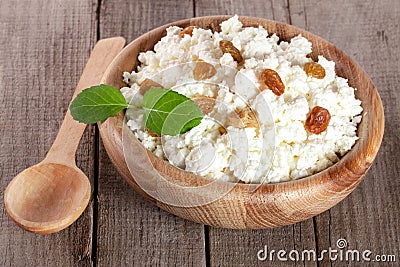 Cottage cheese with raisins in a wooden bowl on a wooden background Stock Photo