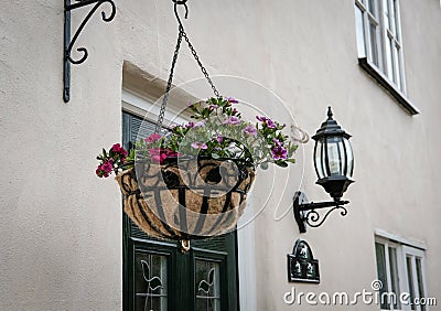 Front view of a luxury, detached cottage showing its hanging basket and security lantern Stock Photo