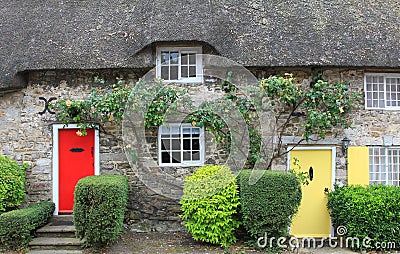 Cottage with straw thatched roof and colorful doors Stock Photo