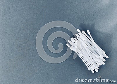 Cotton buds in a container on a gray background. narrow light. Stock Photo
