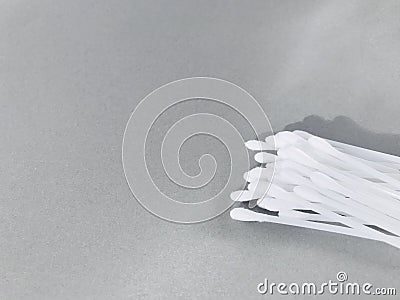 Cotton buds in a container on a grey background. narrow light. Stock Photo