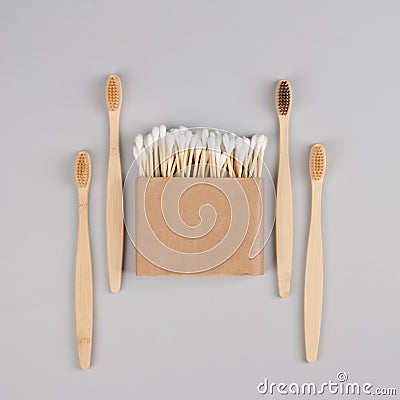 Cotton buds in kraft paper box and natural bamboo toothbrushes on light grey background - zero waste bathroom essentials. Stock Photo