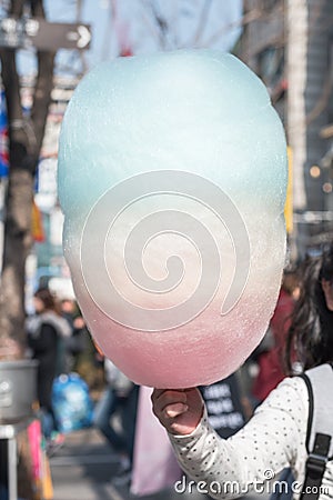 Cotton candy in girl kid`s hand, sugar cloud colorful rainbow color sweet, favorite children`s food in fun fair festival party Stock Photo