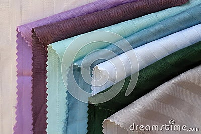 Cotton textiles of white, green, burgundy color top view. Stock Photo