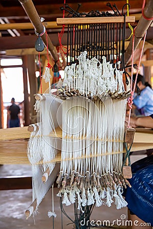 Cotton weaving. Woman weaving cotton on manual loom. Thai cotton handmade. Homespun fabric process. The process of fabric weaving Stock Photo