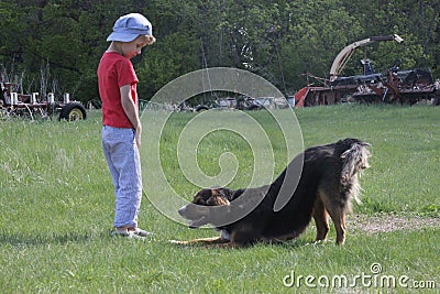 Country boy plays with farm dog Stock Photo