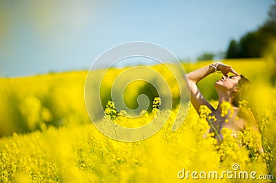 Country girl in a good mood walks in a rape field Stock Photo