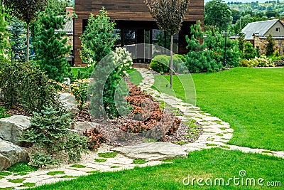 A country house with a beautiful backyard behind the house, landscape design Stock Photo