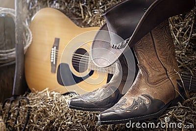 Country music festival live concert or rodeo with cowboy hat guitar and boots in barn Stock Photo