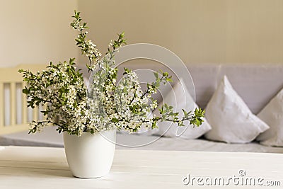 Country style living room. Cherry flower in white pot on wooden table. Still life Stock Photo