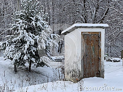 Country toilet in the winter outdoors. Outdoor toilet construction. Cabin - Toilet in the forest on the snow Stock Photo
