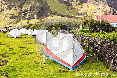 Countryside grass street with a row of drying overturned boats. British Governor flag flying. Edinburgh of the Seven Seas, Tristan Stock Photo