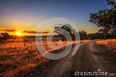 Countryside landscape with rural dirt road at sunset in Australia Stock Photo