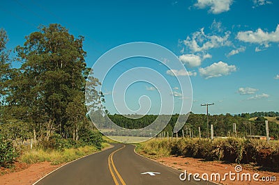 Countryside road on landscape covered by meadows and trees Editorial Stock Photo