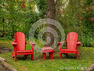 Couple of adirondack chairs in a quiet peaceful location Stock Photo