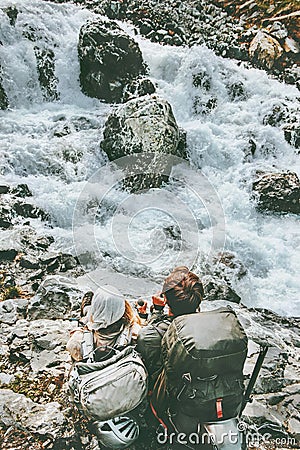 Couple adventurers relaxing at mountain river together Stock Photo