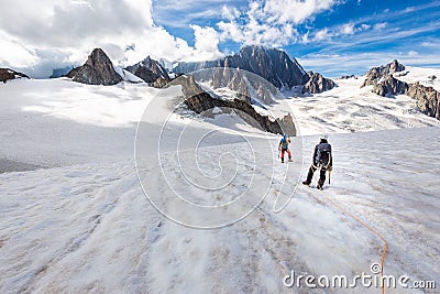 Couple alpinists mountaineers walking glacier slopes. Mont Blanc Stock Photo