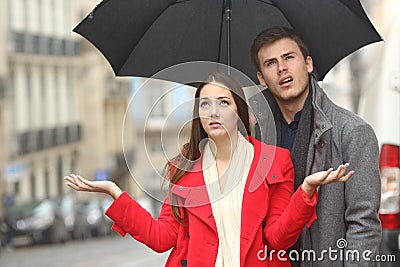 Couple annoyed in a rainy day Stock Photo