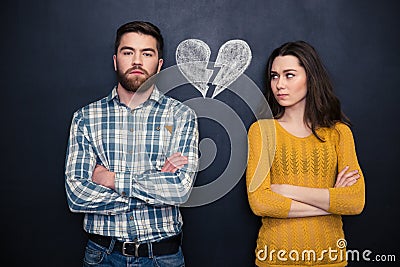 Couple after argument standing separately over blackboard background Stock Photo