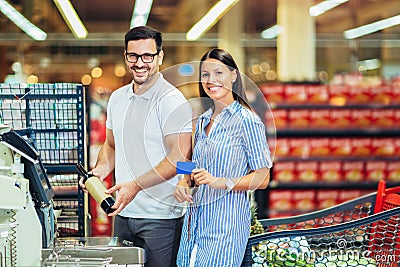 Couple with bank card buying food at grocery store or supermarket self-checkout Stock Photo