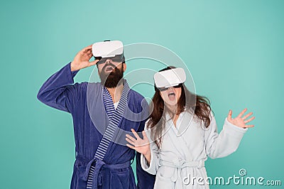 Couple in bathrobes wear vr glasses. Conscious awakening. Return to reality. Man and woman explore vr. VR technology and Stock Photo